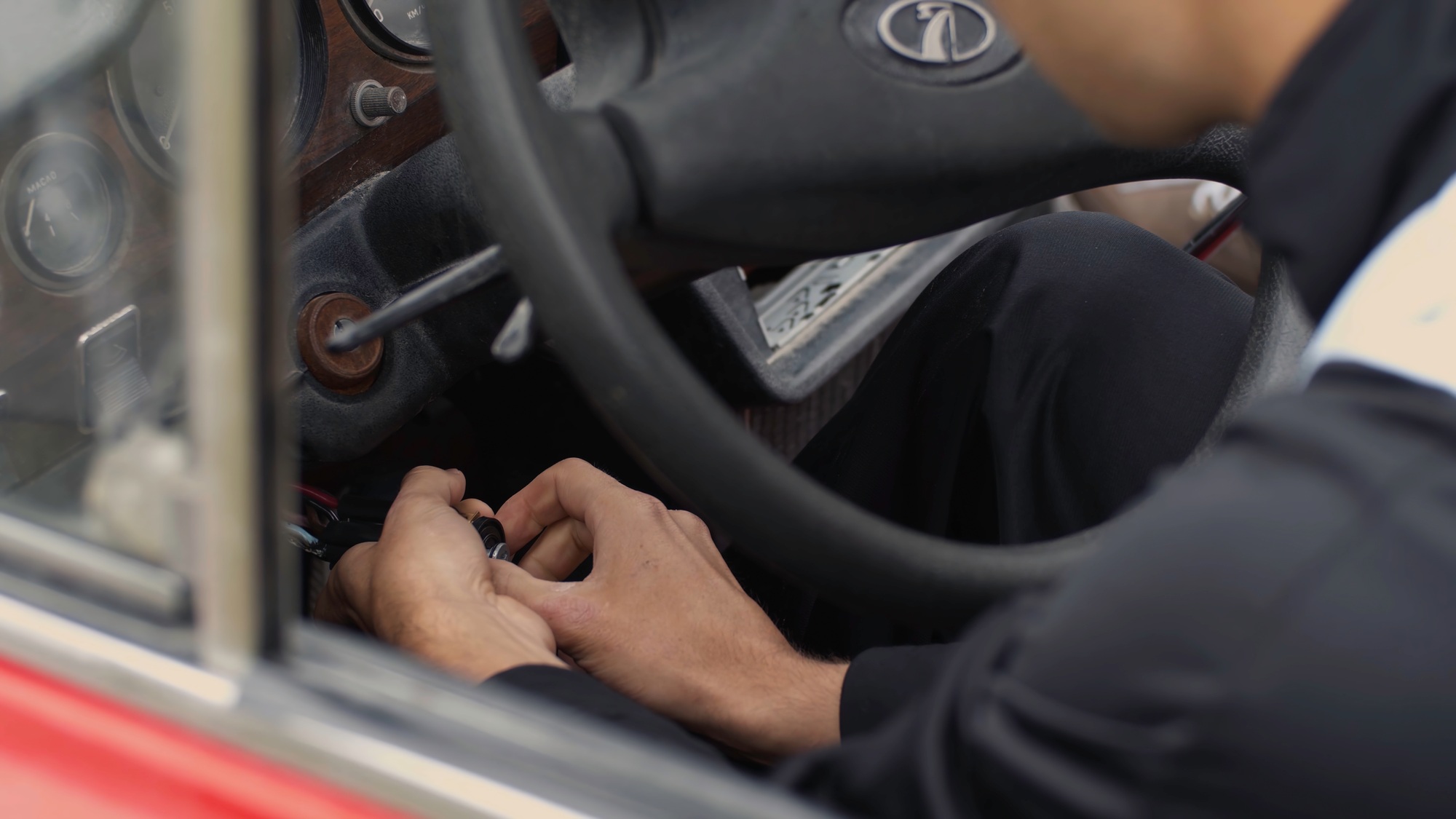 Le jeune homme commence une voiture avec des fils. 